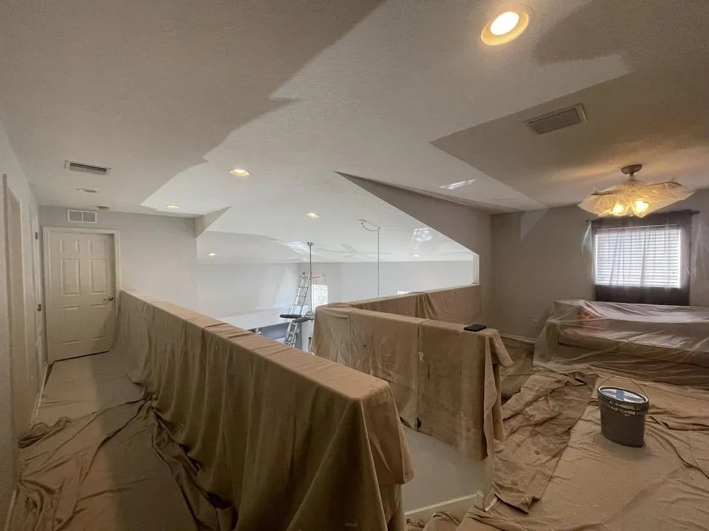 Railings, furniture and floors covered in drop cloths and plastic before painting