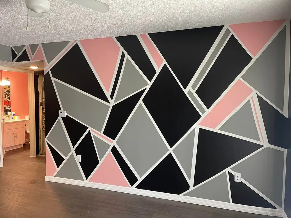 Geometric accent wall painted pink, black and gray