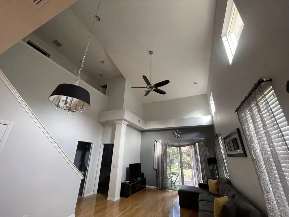 Tall two-story living room with freshly painted white walls